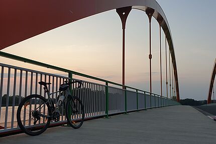 Gravelbike auf der Dattelner Regenbogenbrücke bei Abendstimmung