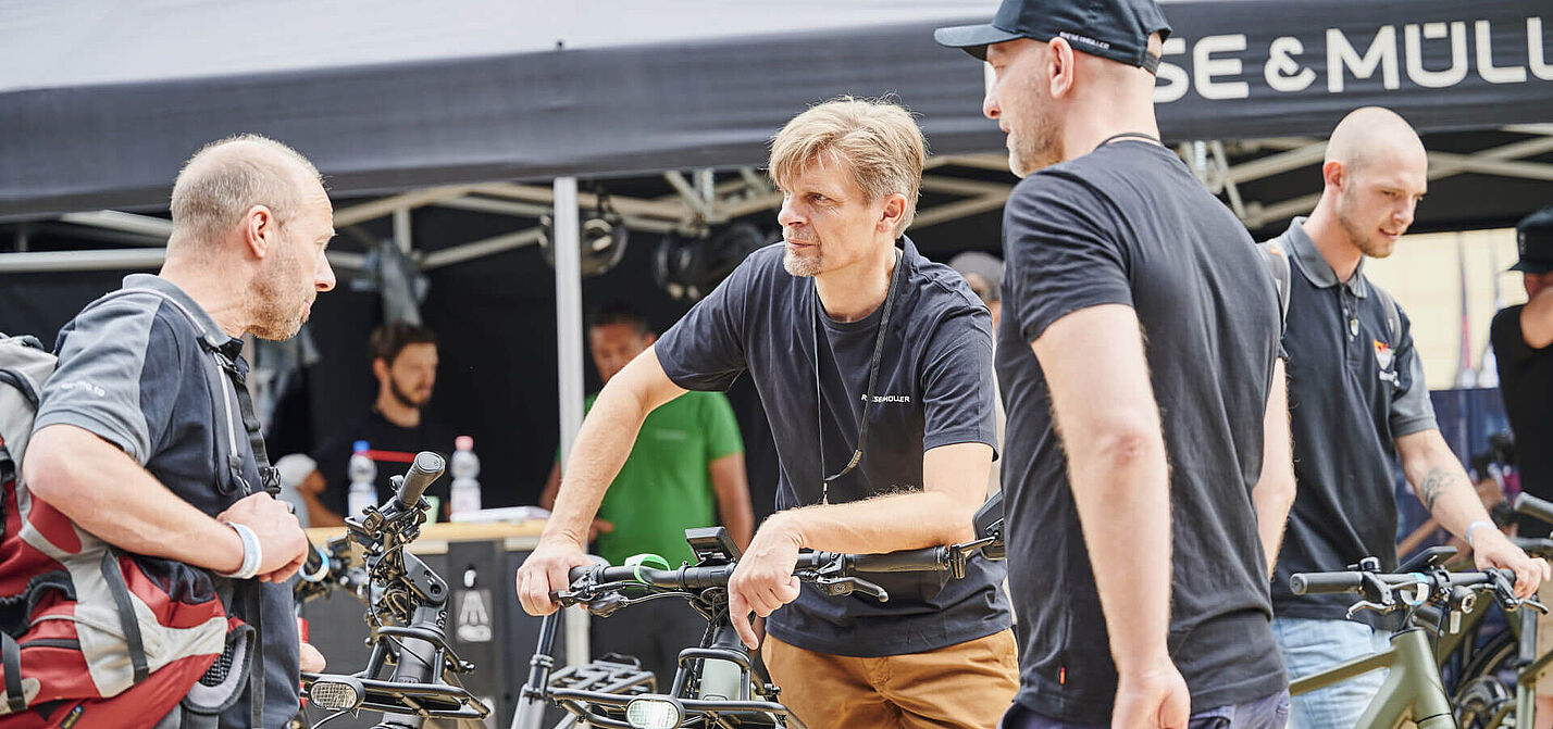 Personen diskutieren über Fahrräder Personen diskutieren über Fahrräder