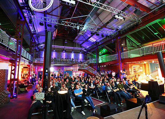 Das Bild zeigt das Publikum des Cycling Film Festival, die sitzend auf Stühlen einen Film schauen.